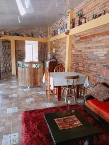 - un salon avec une table et un mur en briques dans l'établissement MI RANCHITO, à Sogamoso