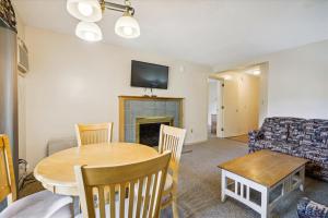 ein Wohnzimmer mit einem Tisch und einem Sofa in der Unterkunft Cedarbrook Deluxe Two Bedroom Suite, With heated pool 10102 in Killington