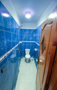 La salle de bains est pourvue de carrelage bleu et de toilettes. dans l'établissement Idriss's hostel, à Taghazout