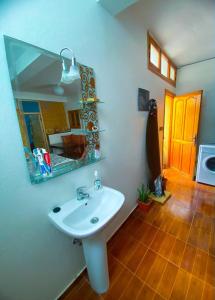 La salle de bains est pourvue d'un lavabo blanc et d'un miroir. dans l'établissement Idriss's hostel, à Taghazout