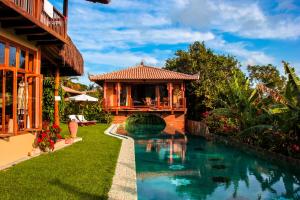 uma casa com piscina ao lado de um edifício em Sagui Boutique Hotel em Arraial d'Ajuda