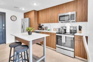 a kitchen with stainless steel appliances and wooden cabinets at Wonderful Unit In Downtown Miami With Free Parking in Miami