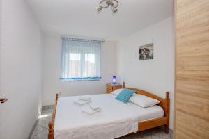 een slaapkamer met een bed met witte lakens en een raam bij Apartments with parking space Jezera, Murter - 5133 in Jezera