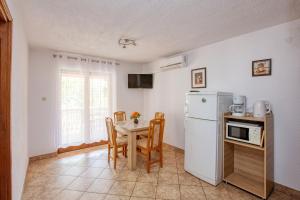 een keuken met een tafel en een witte koelkast bij Apartments with parking space Jezera, Murter - 5133 in Jezera