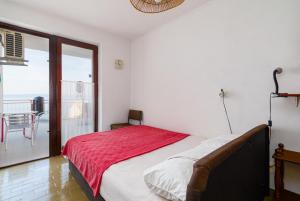 a bedroom with a bed and a balcony at Apartments with WiFi Klenovica, Novi Vinodolski - 5530 in Klenovica