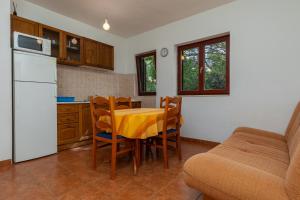 La cuisine est équipée d'une table, de chaises et d'un réfrigérateur. dans l'établissement Apartment Mimice 11045b, à Mimice