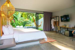 een slaapkamer met een wit bed en een groot raam bij Hotel Piedra Mulata - Adults Only in Doradal