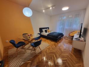 a living room with a table and chairs and a bed at Koala Apartman Székesfehérvar in Székesfehérvár