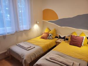 two beds in a room with a teddy bear between them at Koala Apartman Székesfehérvar in Székesfehérvár