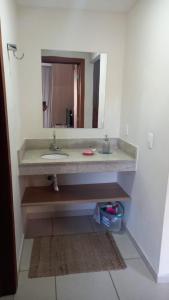 a bathroom with a sink and a mirror at Lindo Flat no Aldeias das Águas in Barra do Piraí
