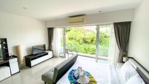 カロンビーチにあるStudio near Karon Beach by Clavisのベッドと大きな窓のあるリビングルーム +21枚の写真