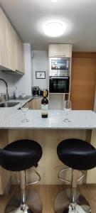 a kitchen with two wine glasses sitting on a counter at Apartamento Greta Río CalleCalle in Valdivia