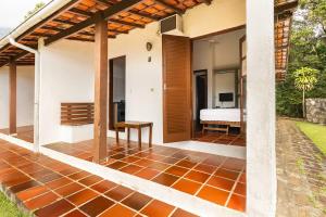 an open patio with a bed in a house at Ilhabela Chalés in Ilhabela