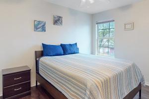 a bedroom with a bed with blue pillows and a window at Brickside Beauty in Killeen