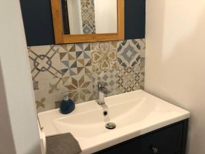 a bathroom with a white sink and a mirror at Charmant Gîte Familial Rénové avec 3 Chambres, Cheminée et Jardin, Proche Le Mans - FR-1-410-332 in Le Mans +15 photos