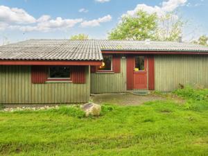 a house with a red door and a yard at Three-Bedroom Holiday home in Struer 1 in Remmer Strand