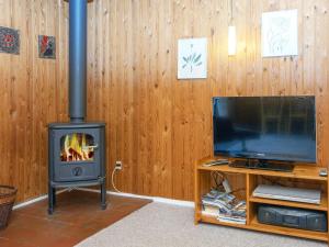 a living room with a stove and a tv at Three-Bedroom Holiday home in Struer 1 in Remmer Strand