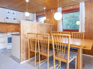 uma cozinha com uma mesa de jantar em madeira e cadeiras em Three-Bedroom Holiday home in Struer 1 em Remmer Strand