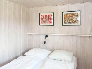 レムヴィーにあるTwo-Bedroom Holiday home in Lemvig 1のベッドルーム(白い枕2つ、棚付)