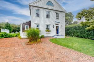 uma casa branca com uma entrada de tijolos em About Time em Nantucket