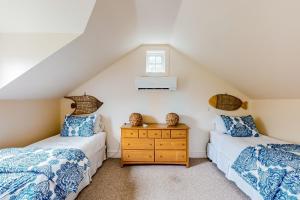 two twin beds in a attic bedroom with a window at About Time in Nantucket