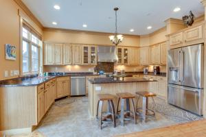 a large kitchen with wooden cabinets and bar stools at Lovely Big Sky Getaway Near Skiing and Golf! in Big Sky