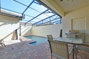 een patio met een tafel en een zwembad bij TVPM-8916AL WWS townhouse in Kissimmee