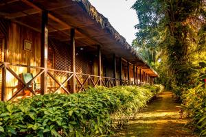 un edificio de madera con una valla junto a las plantas en Sandoval Lake Lodge, en Puerto Maldonado