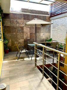 un patio con mesa, sillas y sombrilla en Hidden house, en Ciudad de México