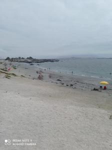 a beach with a group of people and an umbrella at Suite Loreto in Caldera