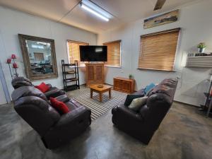 a living room with two couches and a flat screen tv at Everlasting Guesthouse Morowa in Morawa