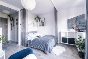 um quarto branco com uma cama e uma televisão em DREAMY modern 3ppl apartment 13 min to Old Town and Central Station em Varsóvia