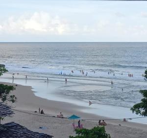 a group of people playing in the water at the beach at LahSelva Pousada Hostel in Itacaré