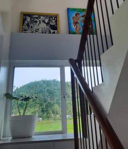 eine Treppe mit einer Topfpflanze und einem Fenster in der Unterkunft Bayay ni Mayang (Fully furnished apartment) in Surigao