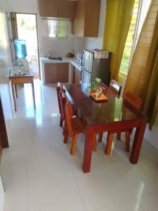 eine Küche mit einem Tisch und Stühlen sowie eine Küche mit einem Kühlschrank in der Unterkunft Bayay ni Mayang (Fully furnished apartment) in Surigao