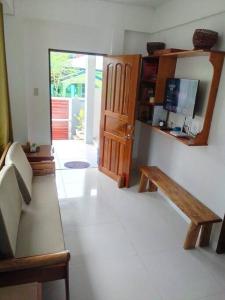 ein Wohnzimmer mit einer Bank und einer Tür in der Unterkunft Bayay ni Mayang (Fully furnished apartment) in Surigao