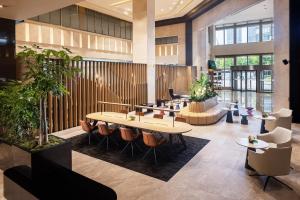 a lobby with tables and chairs and plants at Sheraton Grand Incheon Hotel in Incheon
