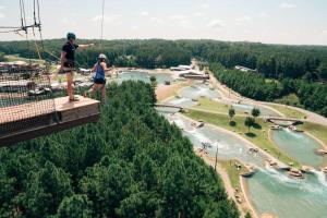 two people standing on a zip line over a river at Charming, Cozy Home close to Uptown, Airport & Whitewater Center in Charlotte