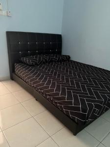 a bed in a room with a black bed frame at Amir homestay kg pandan in Kuantan
