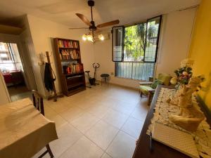 sala de estar con ventilador de techo y mesa en Comodo Y Acogedor Departamento En La Boca en Buenos Aires