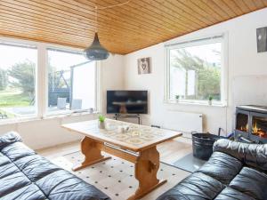 a living room with a table and a couch at Three-Bedroom Holiday home in Harboøre 12 in Harboør