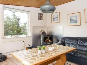a living room with a table and a fireplace at Three-Bedroom Holiday home in Harboøre 12 in Harboør