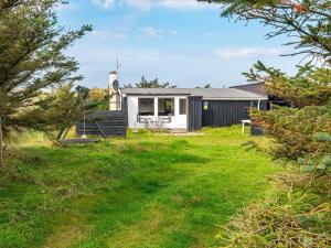 a cottage with a grassy yard in front of it at Three-Bedroom Holiday home in Harboøre 12 in Harboør