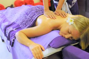 a girl laying on a bed with a flower on her back at Private Pool Villas Kuta Bali in Kuta