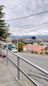 una calle de la ciudad con una valla blanca y edificios en Encanto Fueguino calido centrico wifi para dos en Ushuaia