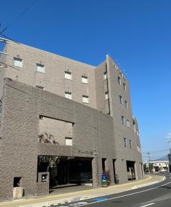 a large brick building on the corner of a street at Hotel Lakeland Hikone in Hikone