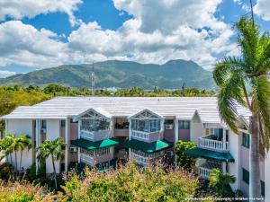 a row of houses with palm trees and mountains in the background at Paramount Views in San Felipe de Puerto Plata