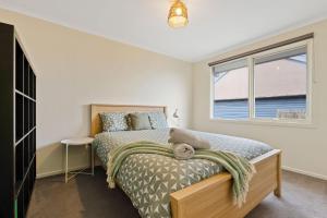 1 dormitorio con cama y ventana en Back Beach Oasis, en Smiths Beach