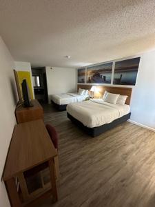 a hotel room with two beds and a table at Days Inn by Wyndham Decatur Priceville I-65 Exit 334 in Decatur