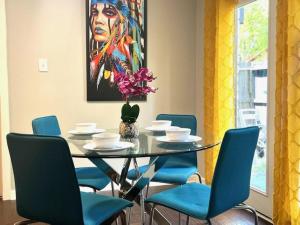 a dining room with a glass table and blue chairs at 1 Galleria Downtown 3BR- Free Parking in Houston